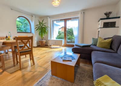 Helles Wohnzimmer mit gemütlicher Couch und grüne Kissen